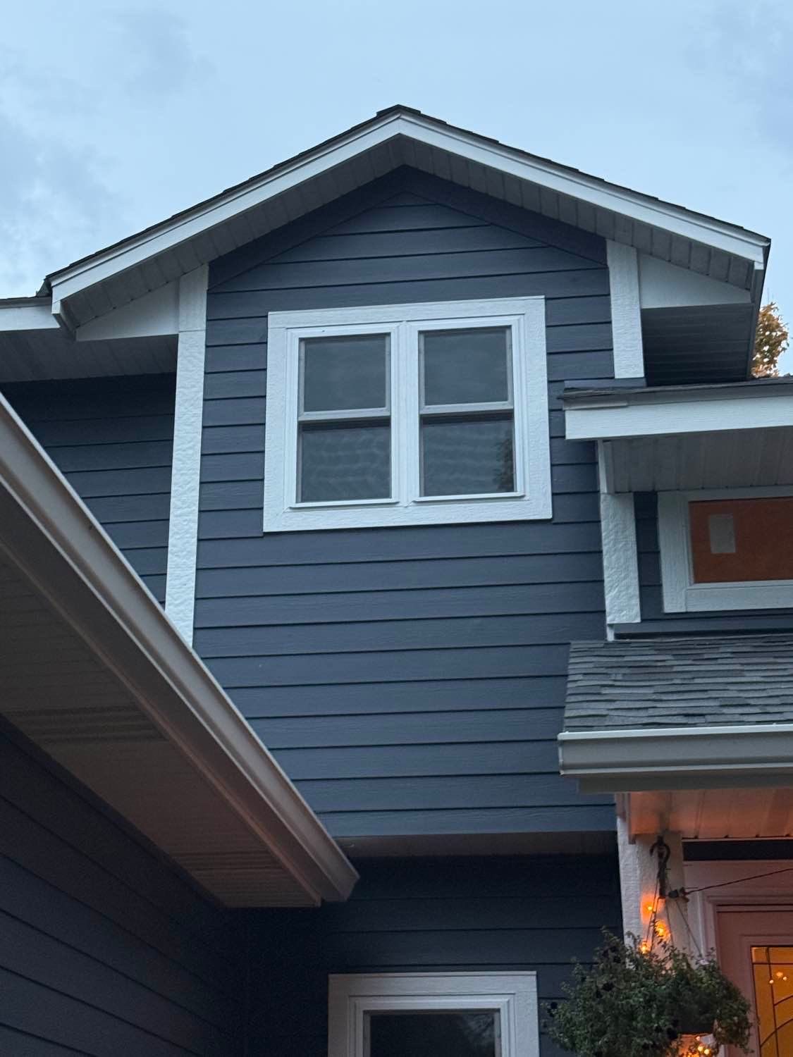 Navy two-story home in St. Michael with newly installed white windows