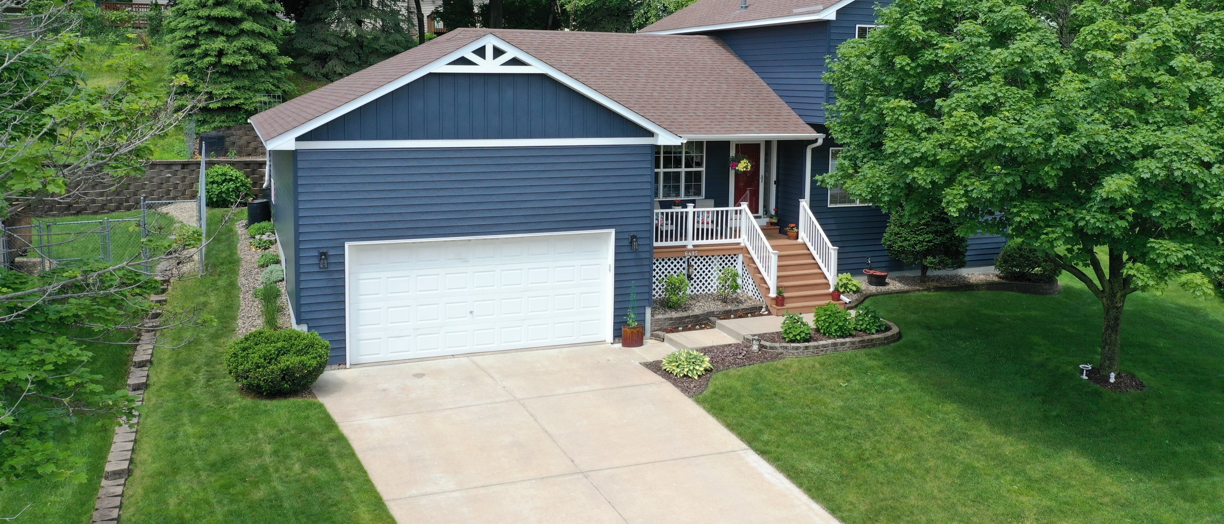 Navy-sided two-story home with new white windows and trim, fresh landscaping and lawn — recent MacTaggart Construction exterior project